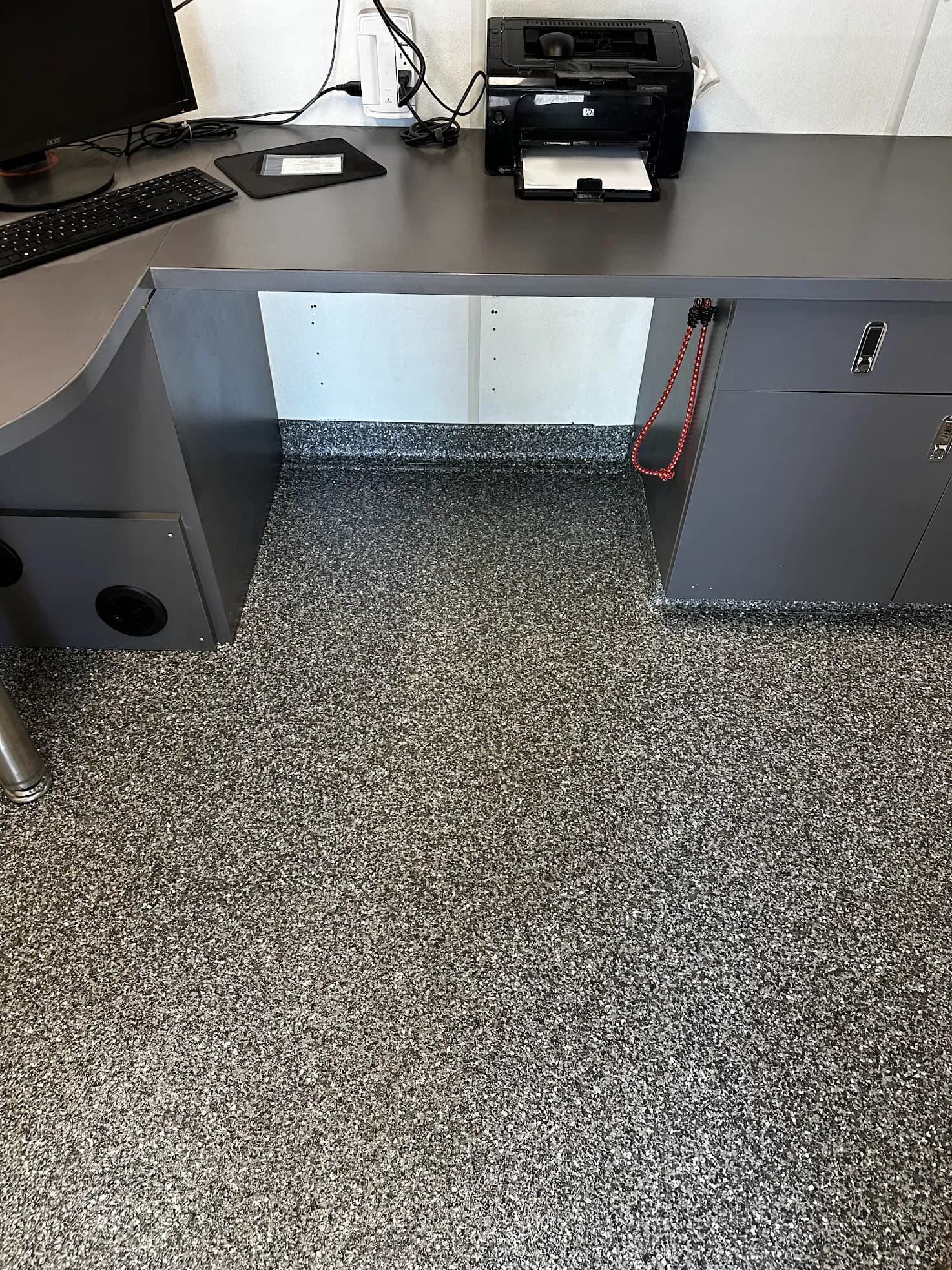 An office with black, white, and gray flecked concrete coated flooring.