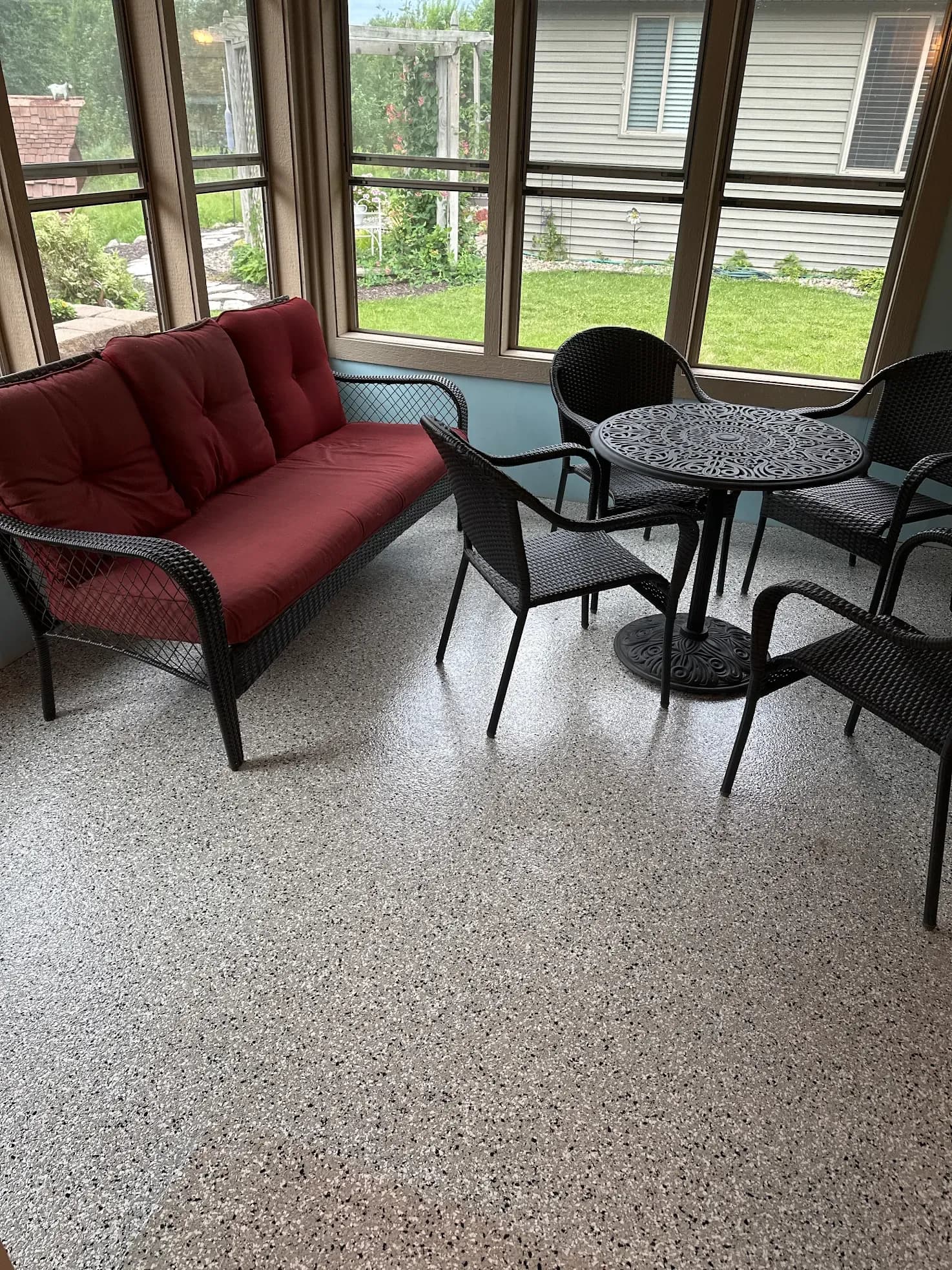 A patio porch sunroom with new flecked concrete coating flooring.