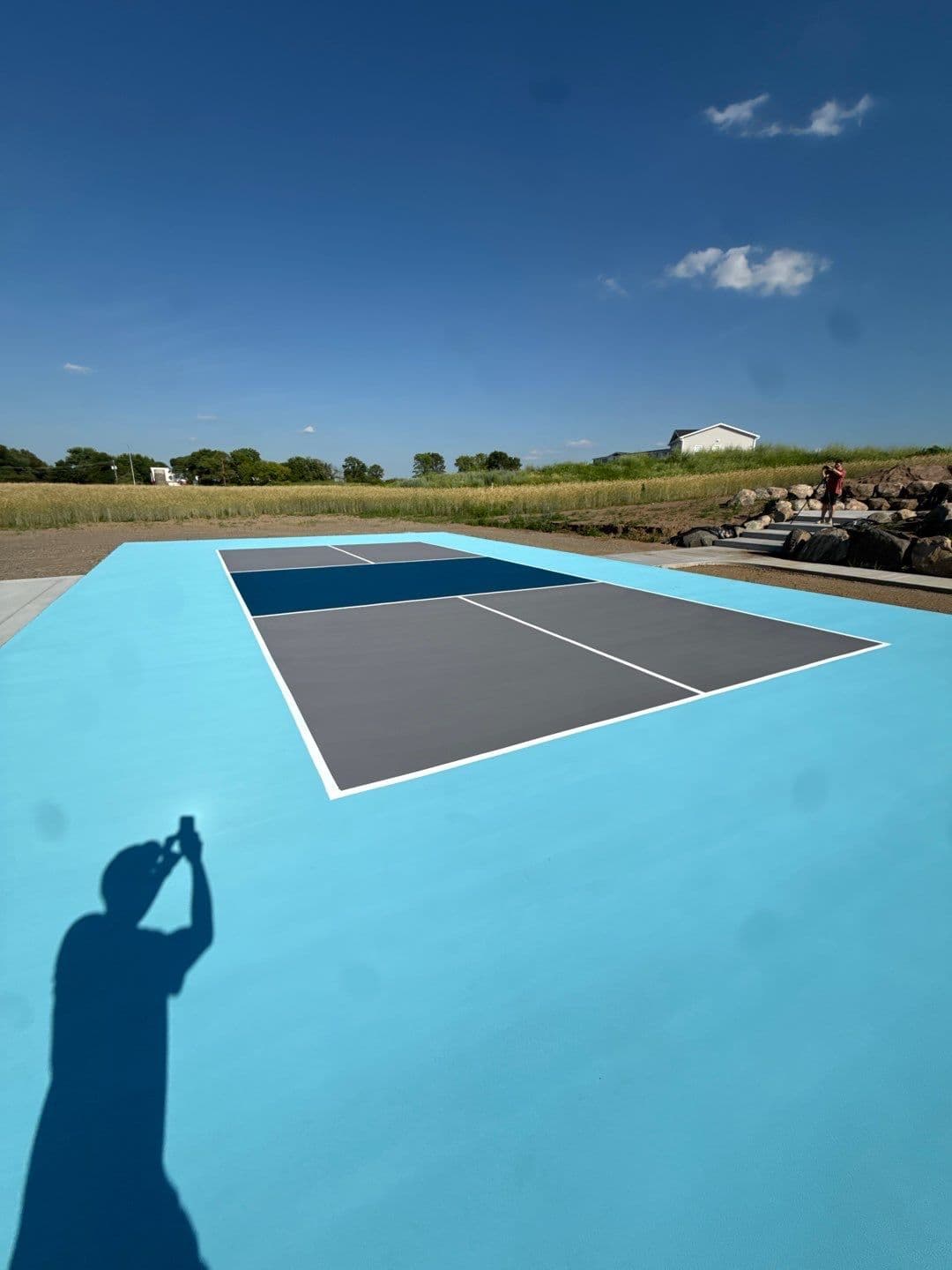 A newly-coated black, blue, and white pickleball concrete flooring court.