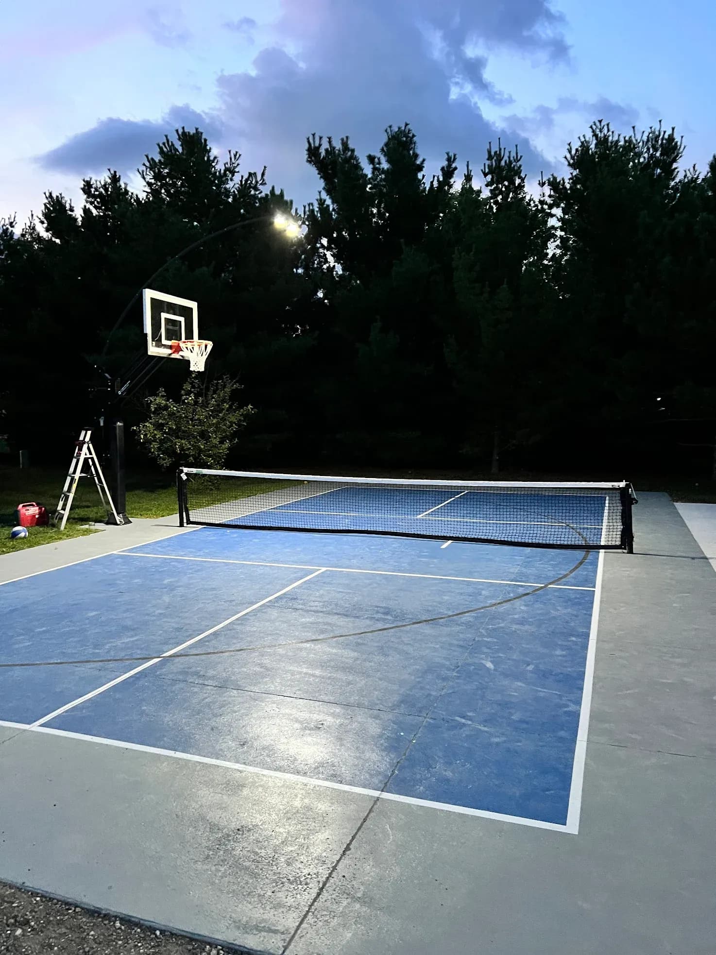 An outdoor pickleball court with concrete coated flooring.